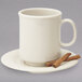 A white saucer with two cinnamon sticks on it.