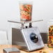 An Edlund Four Star portion scale with a plastic container full of pasta on it.