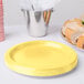 A yellow paper plate with a variety of food on it.
