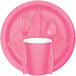 A pink Creative Converting paper plate with a fork and spoon on it.