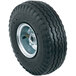 A close-up of a black tire with a silver rim.