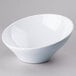 A white Elite Global Solutions melamine bowl with a curved bottom on a gray surface.