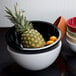 A white Elite Global Solutions melamine bowl with fruit in it.