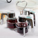 A Tablecraft 3-ring syrup dispenser caddy on a table in a breakfast diner.