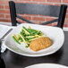 A Tuxton white china square coupe pasta plate with food on it.