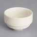 A Tuxton eggshell stackable china soup cup on a gray surface.