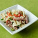 A Tuxton white porcelain mini footed square bowl filled with pasta salad and meat.