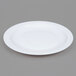 An Arcoroc white narrow rim side plate on a gray background.