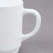 An Arcoroc white stacking mug with a handle.