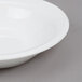 An Arcoroc white opal fruit bowl with a white rim.