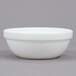 An Arcoroc white glass bowl with a white rim on a gray background.