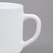 An Arcoroc white stacking mug with a handle.