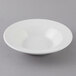 A white Tuxton tall pasta bowl on a gray surface.