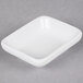 A Tuxton porcelain white rectangular sauce dish.