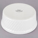 A white Tuxton ramekin with swirl sides.