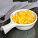 A Tuxton eggshell china bowl filled with macaroni and cheese with a fork.