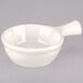 A Tuxton eggshell white china bowl with a handle.