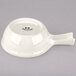 A white Tuxton china bowl with a handle.