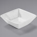 A white square bowl on a gray surface.