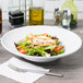 A salad with meat and vegetables in a Tuxton white porcelain bowl.