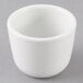 A Tuxton porcelain white Chinese sake cup on a gray surface.