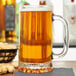 A Libbey glass mug of beer on a table.