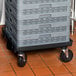 A black Vollrath Traex rack dolly base for plastic crates.