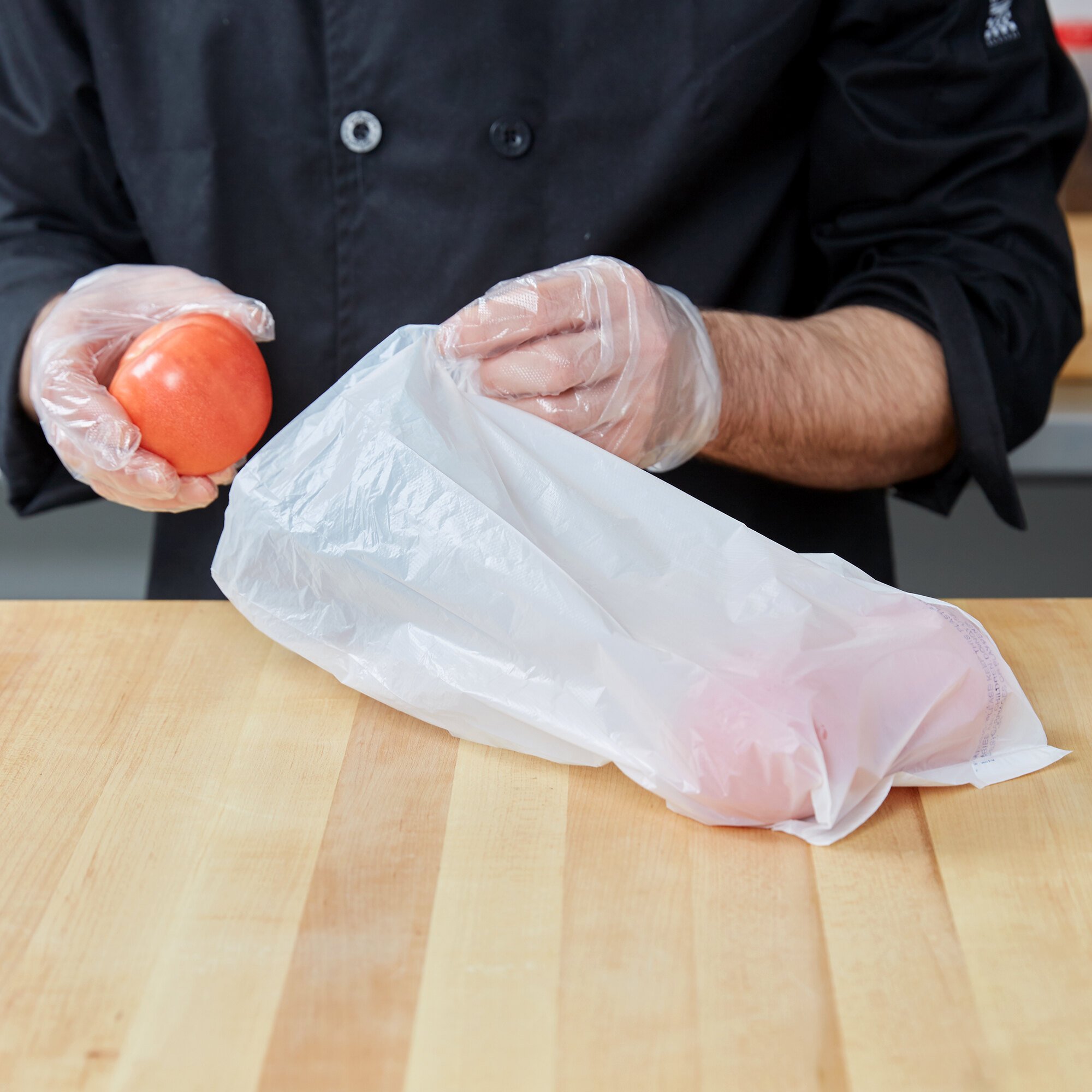 Chef placing tomatoes in white HDPE plastic bag
