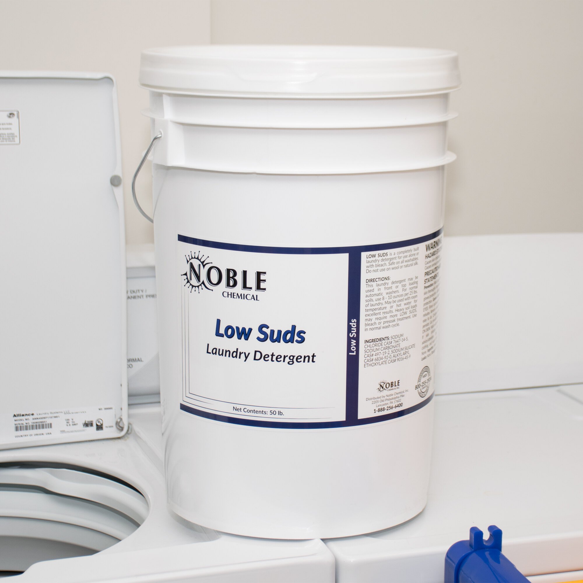 Bucket of Noble Chemical Low Suds detergent on top of a washer
