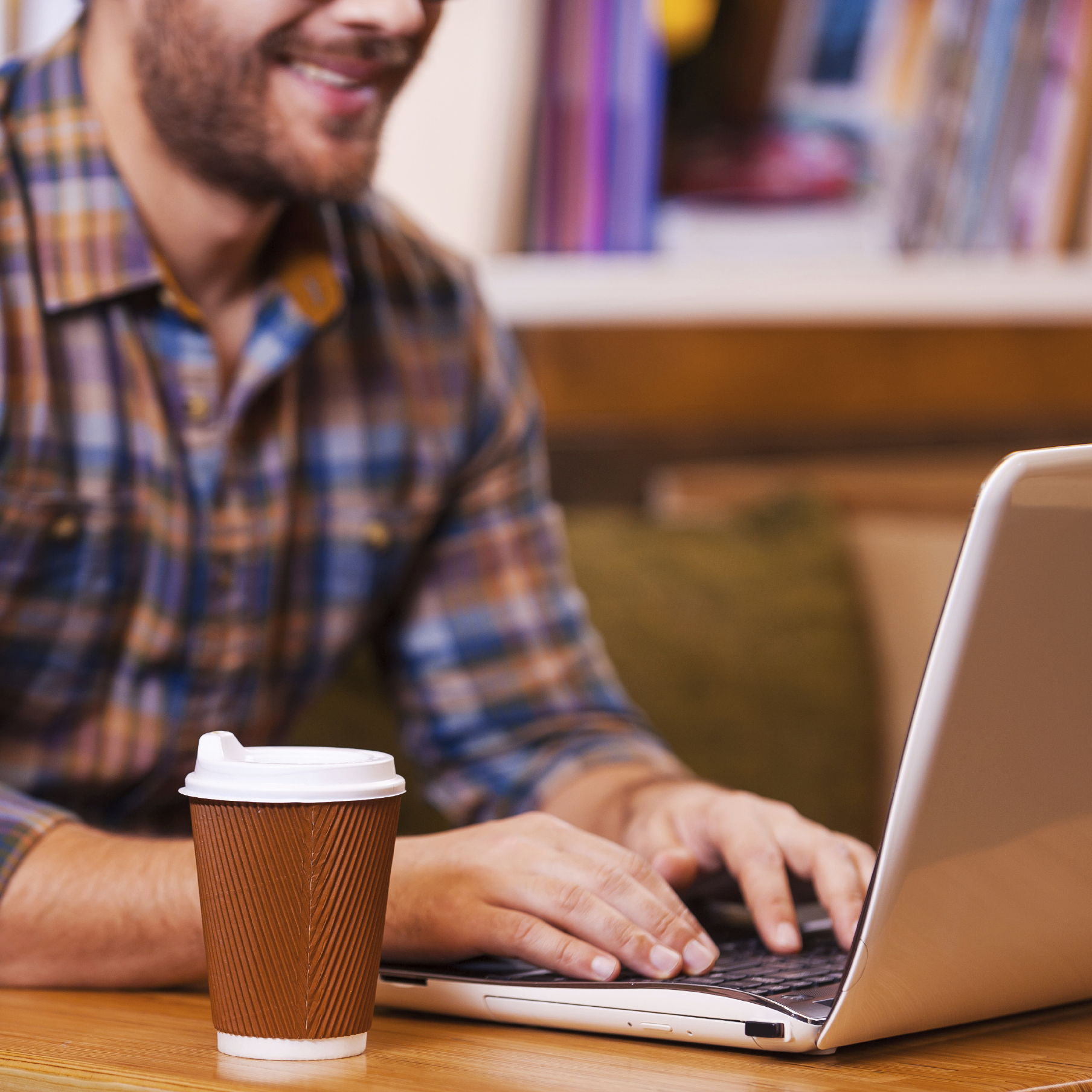 man working on a computer in a cafe