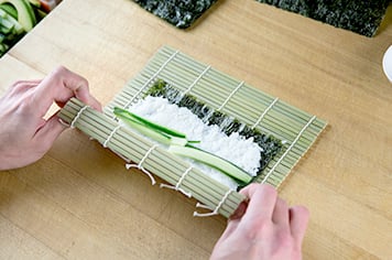 rolling sushi with a bamboo mat