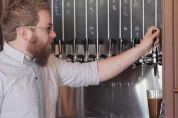 bartender demonstrating how to pour a beer on nitro