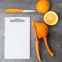orange next to a juicer and cutting board