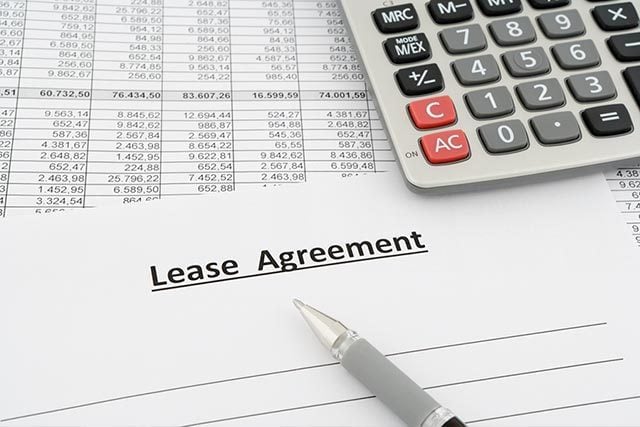 lease agreement contract with pen and calculator
