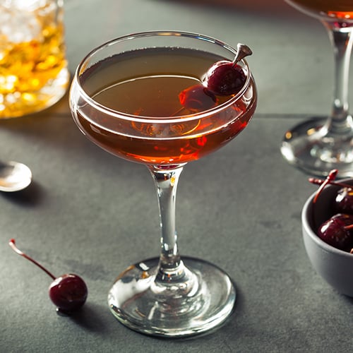 Manhattan cocktail with cherries on a pick