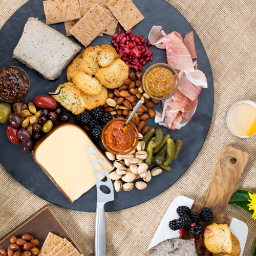 charcuterie board with meat, cheese, pickles, and crackers
