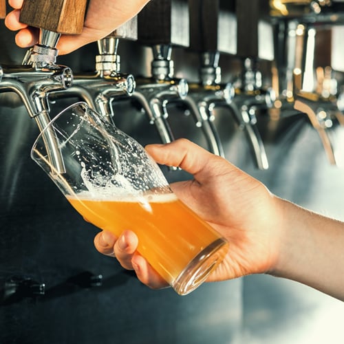 Bartender pouring beer out of a commercial beer tap