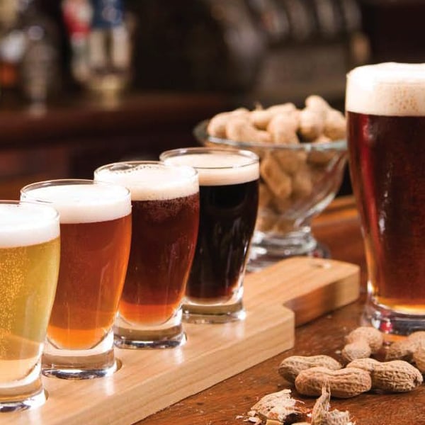 Wooden sampler paddle with four types of beer