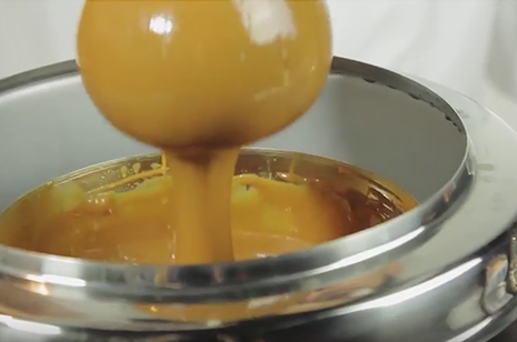 melted caramel dripping off apple into can