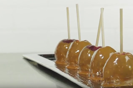 caramel apples with skewers in a row