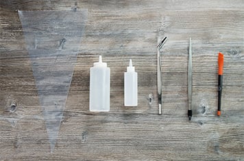 food garnishing tools arranged side by side on a wood background