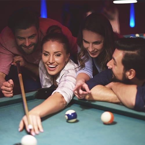 Customers playing billiards at a bar