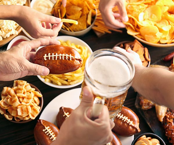 Hands reaching for plates of football appetizers