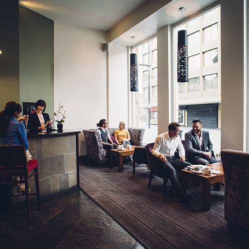 people eating and drinking in a hotel restaurant with a bar