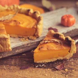 rustic wooden cutting board with a hearty slice of freshly baked pumpkin pie