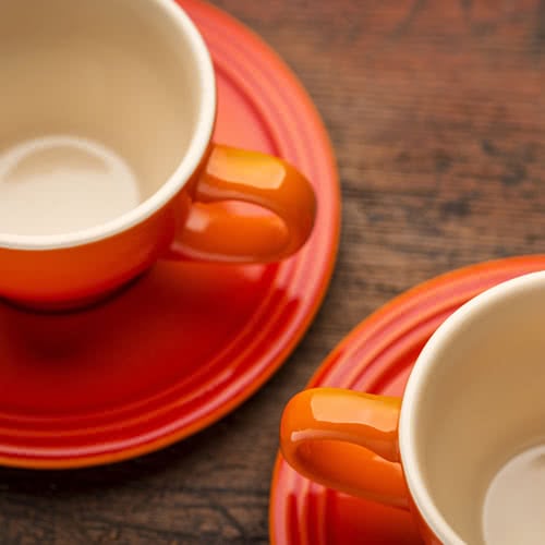 orange stoneware cups and saucers