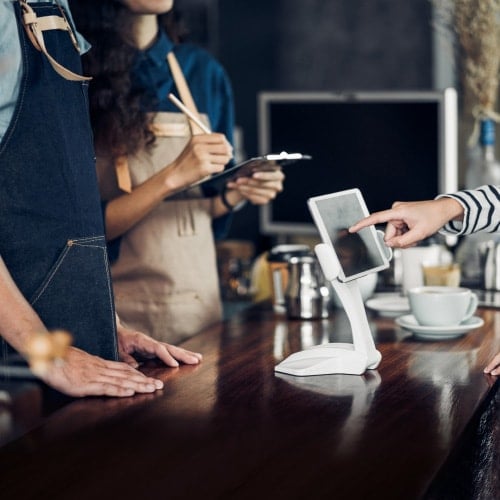 customer at restaurant counter signs tablet with finger