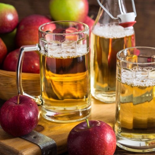 glasses of hard cider next to apples