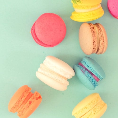 assortment of macaroons on a mint green background