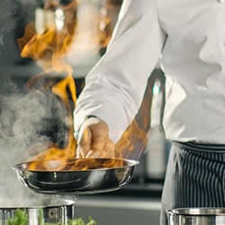 chef holding a hot frying pan